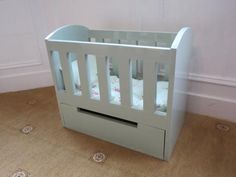 a baby crib in the corner of a room with white walls and flooring