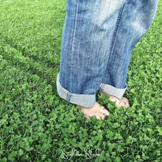 a person standing in the grass with their feet up