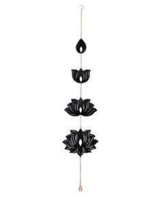 three black and white flowers hanging from a hook on a wall in front of a white background