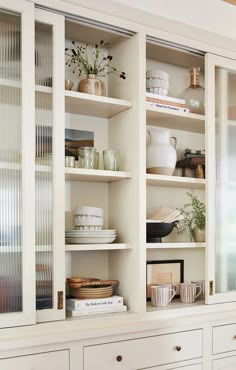 the shelves are filled with dishes and vases