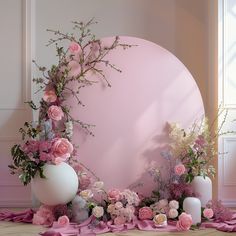 a table with flowers and candles on it in front of a pink circle wallpaper