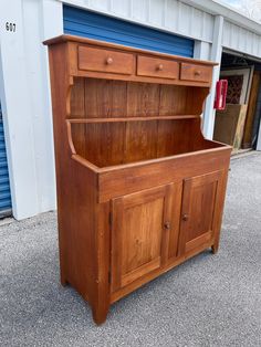 an old wooden dresser sitting in front of a building