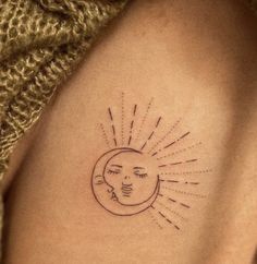 a woman's arm with a sun and moon tattoo on the left side of her shoulder