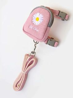 a pink bag with a flower on it and a lanyard attached to the strap