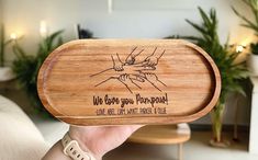 a person holding up a wooden tray that says, we love you mompool