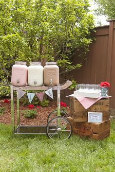 an old fashioned cart with drinks on it in the grass