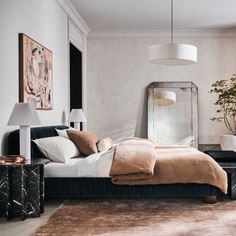 a bedroom with a bed, mirror and lamp in it's centerpieces