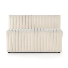 an upholstered white couch sitting on top of a white floor next to a wall