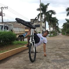 a man is doing a handstand on his bike