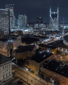 an aerial view of a city at night with tall buildings and skyscrapers in the background