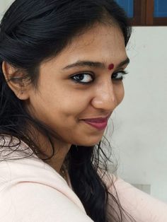 a close up of a person with a smile on her face and long black hair