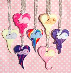 a bunch of necklaces that are hanging on a chain in front of a pink background