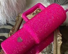 a pink purse sitting on top of a table next to a white and gold chair