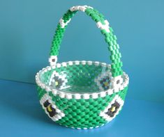 a green and white basket sitting on top of a blue table