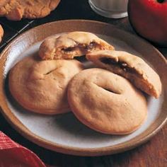 some cookies are on a plate with an apple in the background