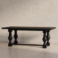 a black table sitting on top of a hard wood floor next to a white wall