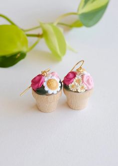 two small cupcake earrings with flowers on them