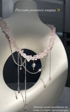 a white vase sitting on top of a table covered in beads and chain necklaces