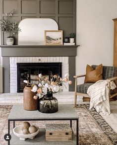 a living room filled with furniture and a fire place in front of a mirror on the wall