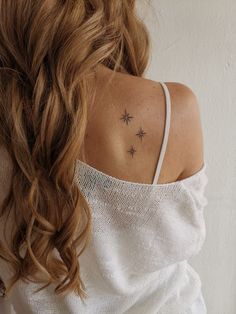 the back of a woman's shoulder with stars on her left and right arm