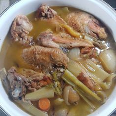 a white bowl filled with meat and vegetables