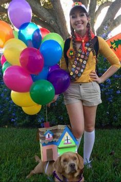 a woman standing next to a dog with balloons on her head