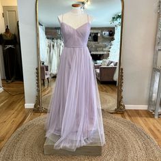 a dress on display in front of a mirror with a mannequin behind it