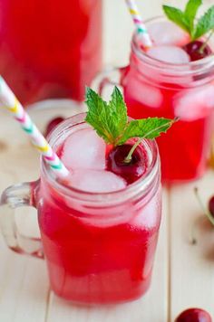 two glasses filled with red liquid and cherries