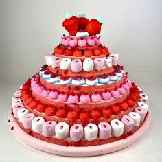 a multi layered cake with strawberries and marshmallows