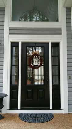 a black front door with a wreath on it