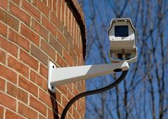 a security camera attached to the side of a brick building