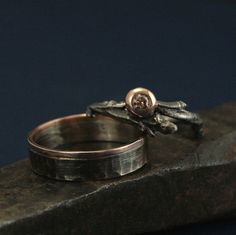 two wedding rings sitting on top of a rock