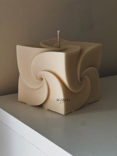 a candle holder sitting on top of a white shelf