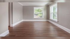 an empty room with wood floors and white trim on the walls is pictured in this image