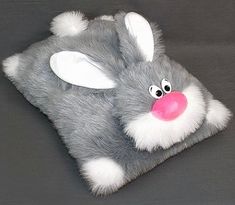 a gray stuffed animal with pink nose and ears