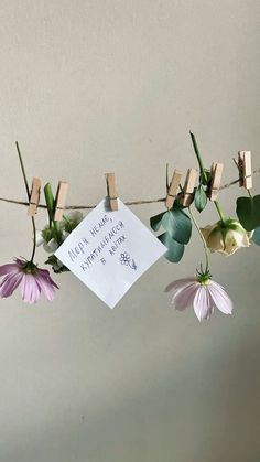 flowers hanging from clothesline with note attached to them