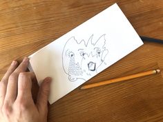 a person is drawing on paper with pencils