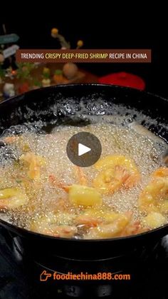 the video is showing how to cook shrimp in a wok on the stove top