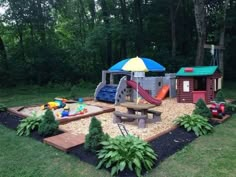 an outdoor play area in the middle of a yard with toys and sandboxes