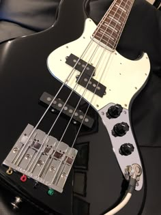 an electric bass guitar sitting on top of a black chair