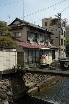 an apartment building next to a river with laundry hanging on the clothes line above it