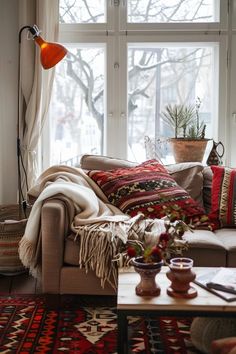 a living room filled with furniture and a large window next to a rug covered coffee table