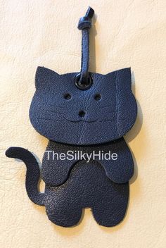 a cat shaped luggage tag hanging on a wall