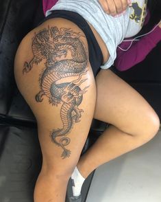 a woman with a dragon tattoo on her thigh