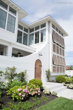 a white building with lots of windows and plants