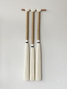 three white cricket bats hanging on the wall