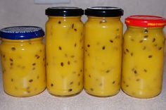 four jars filled with pickles sitting on top of a counter