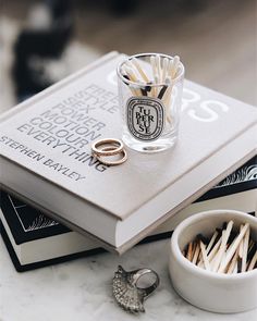 two wedding rings are sitting on top of a book next to some matchsticks