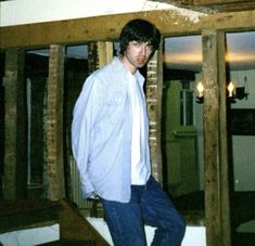 a young man standing on top of a wooden beam in an unfinished room with exposed beams