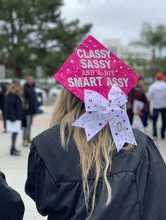 a woman wearing a pink graduation cap that says classy sassy and the smart asy